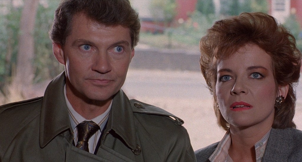 Larry (Andrew Robinson) and Julia (Clare Higgins) standing in a doorway.