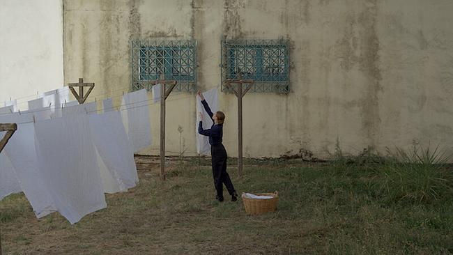 Iro (Agathe Bonitzer) hanging up some washing in the prison courtyard.