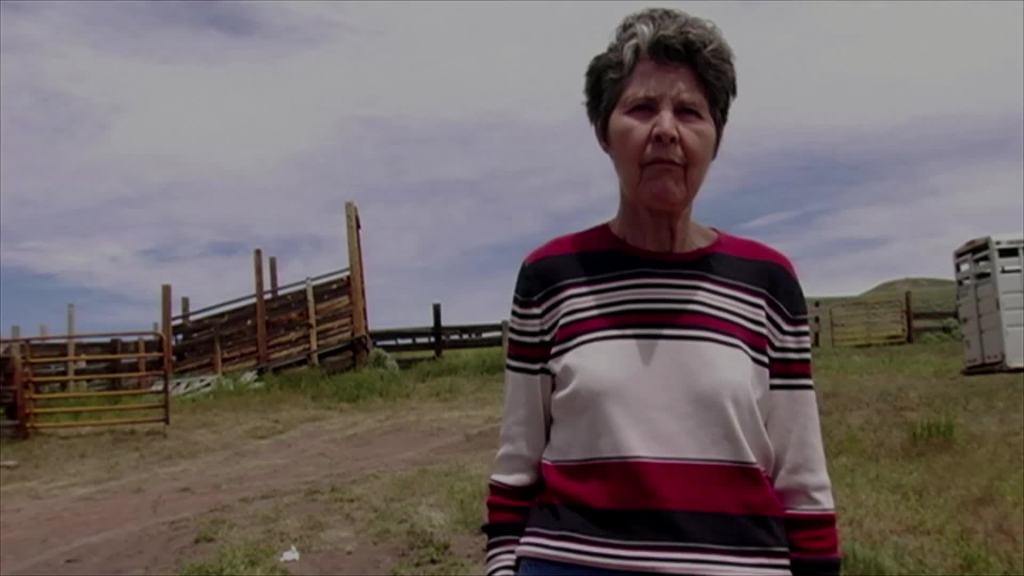 Kirsten Johnson's mther standing on their farm.