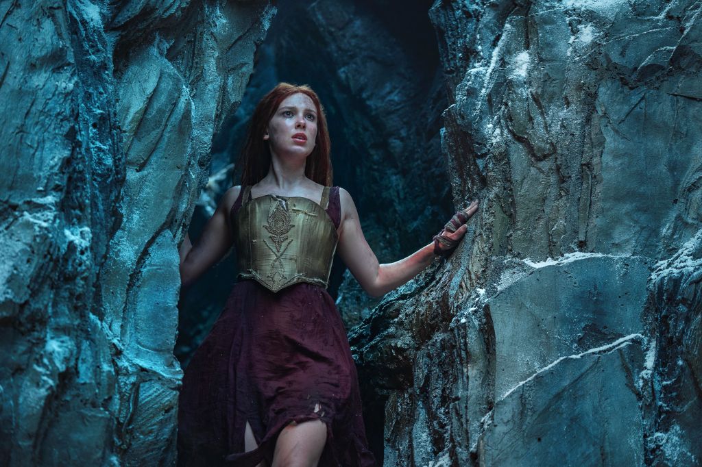 Elodie (Millie Bobby Brown) looking out from a cave.