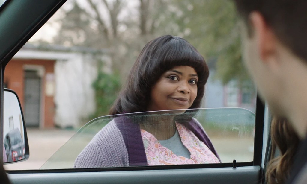 Sue Ann (Octavia Spencer) smiling through the window into a car.