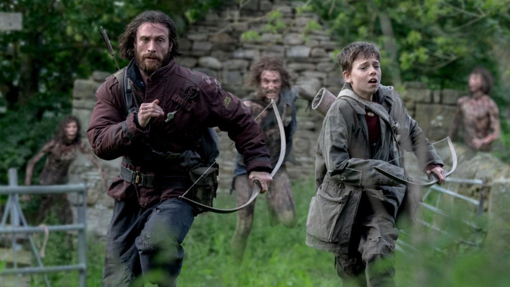 Jamie (Aaron Taylor-Johnson) and Spike (Alfie Williams) running from a horde of zombies.