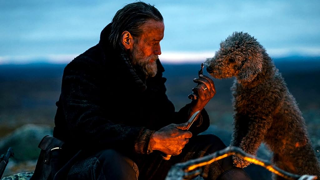 Aatami (Jorma Tommila) giving his dog a treat.