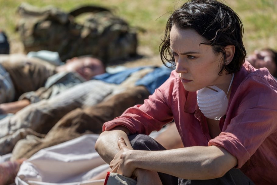 Ava (Daisy Ridley) sitting next to a few lined-up corpses.