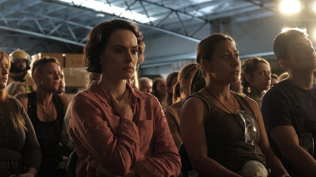 Ava (Daisy Ridley) sitting in a group of volunteers, looking stricken.