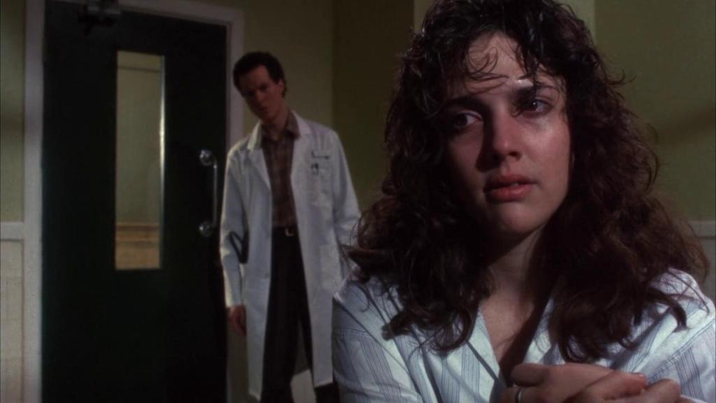 Kirsty (Ashley Laurence) looking disheveled, Kyle (William Hope) standing behind her. He is wearing a doctor's coat. 