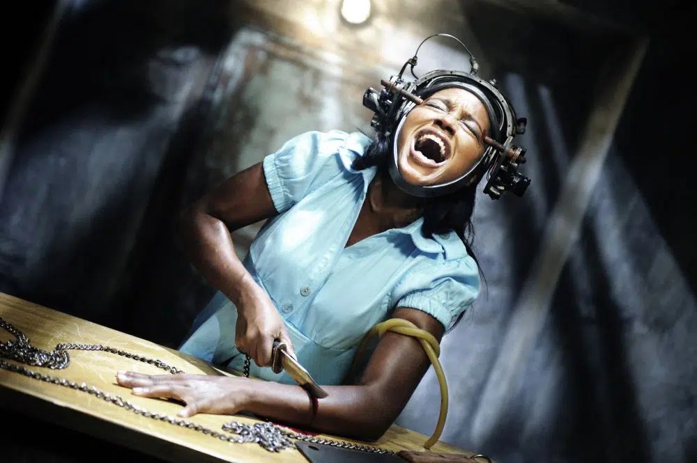 Simone (Tanedra Howard) screaming as she cuts into her own arm.