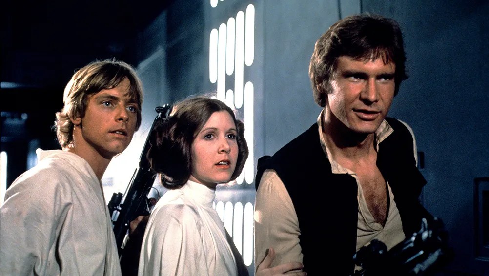 Luke (Mark Hamill), Leia (Carrie Fisher) and Han (Harrison Ford) looking at somebody.