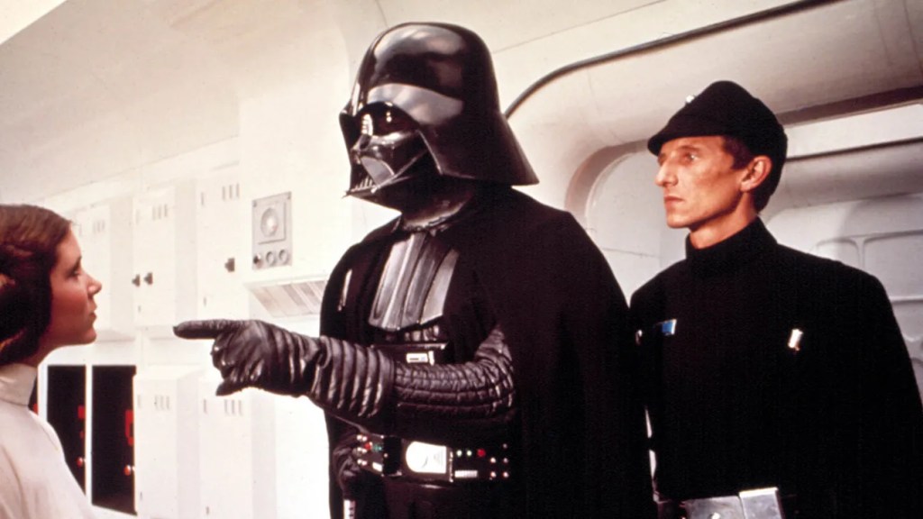 Darth Vader (David Prowse) pointing at Leia (Carrie Fisher).
