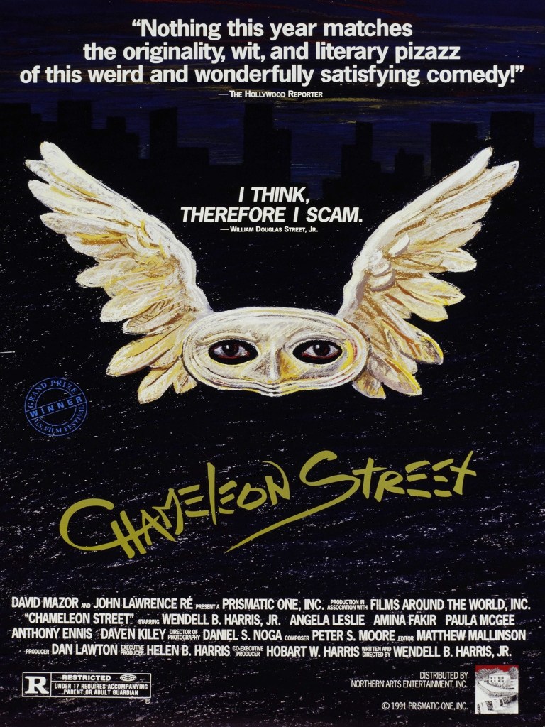 The movie poster showing a white mask with wings out of which dark eyes are looking. A skyline can just be made out in the background in black on dark blue. 