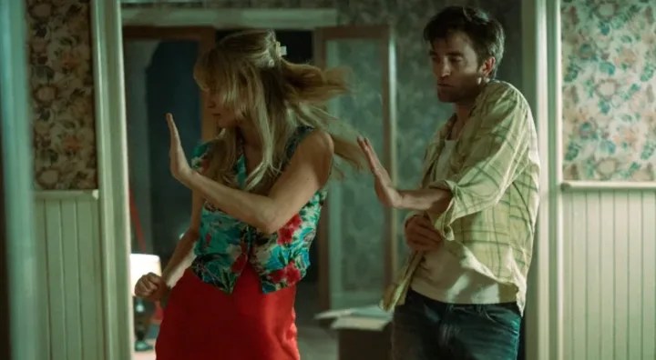 Grace (Jennifer Lawrence) and Jackson (Robert Pattinson) dancing wildly in their freshly moved in home.