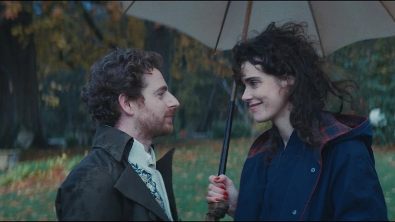 Félix (Pablo Pauly) and Agathe (Camille Rutherford) smiling at each other under an umbrella.