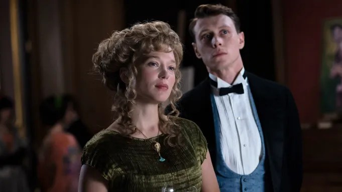 Louis (George MacKay) and Gabrielle (Léa Seydoux) in historical dress, looking at something together.