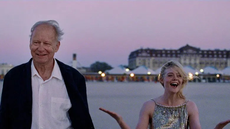 Gustav (Stellan Skarsgård) and Rachel (Elle Fanning) on a beach, smiling broadly.