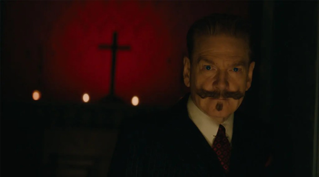 Poirot (Kenneth Branagh) looking very serious, his mustache mirroring the cross that is behind him.