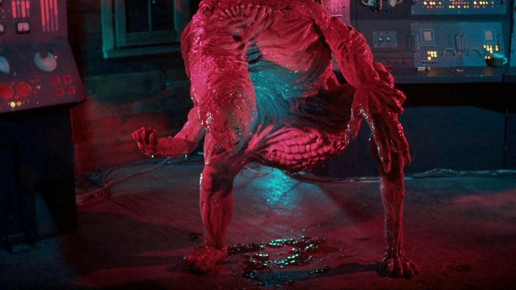 A strange creature that looks like a mix of human and arm chair, dripping slimy fluid, its face smiling.