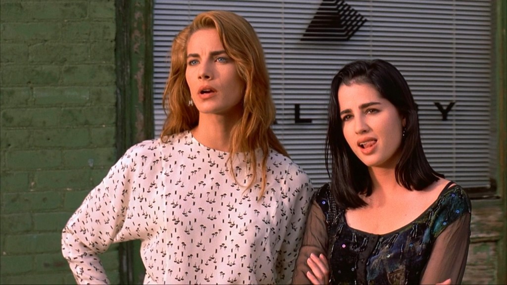 Joey (Terry Farrell) and Terri (Paula Marshall) looking at something with critical expressions.