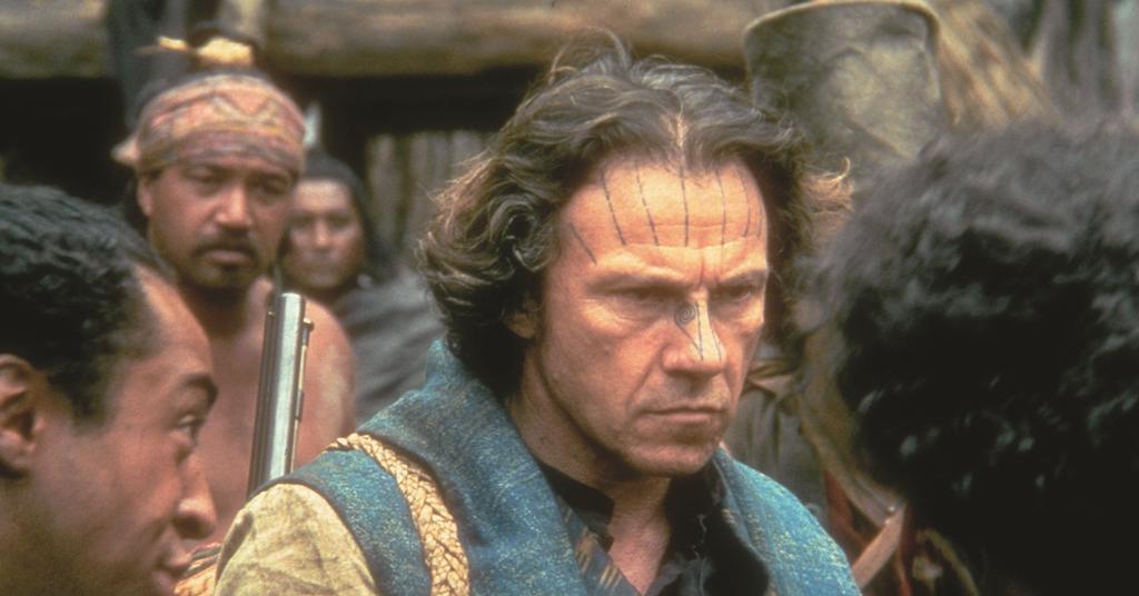 George (Harvey Keitel) surrounded by a few Maori men. He has tribal facial tattoos himself.