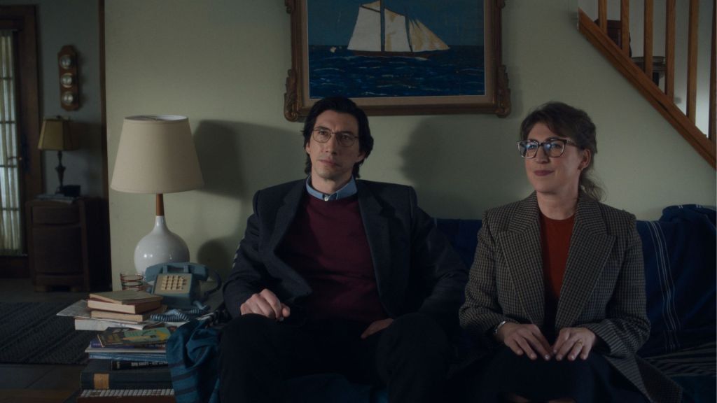 Jeff (Adam Driver) and Emily (Mayim Bialik) sitting on a couch, looking vaguely uncomfortable.