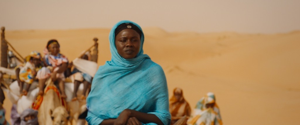 Sira (Nafisatou Cisse) riding in a caravan.