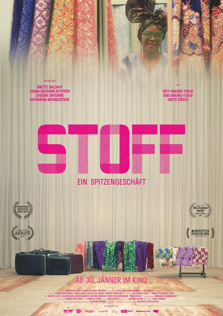 The movie poster showing a Black woman with a Nigerian head-scarf in a fabric store, as well as an empty stage with suitcases and colorful fabrics as props.