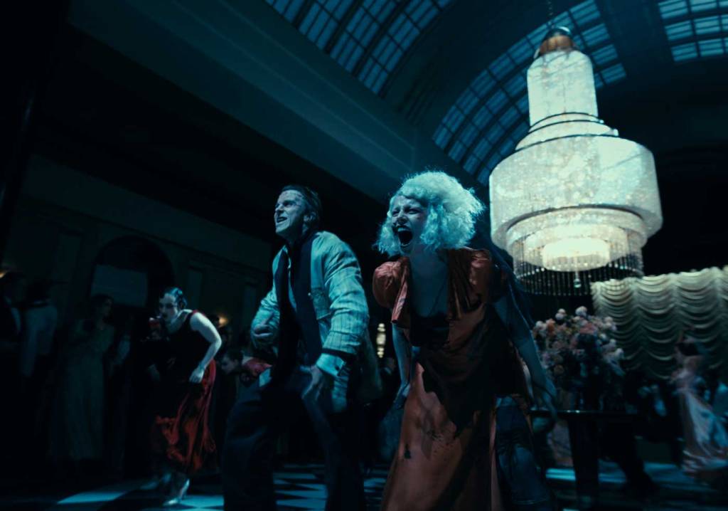 Frank (Christian Bale) and The Bride (Jessie Buckley) dancing wildly at a fancy party.