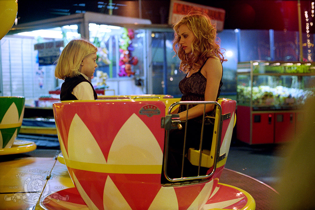 Molly (Brittany Murphy) and Ray (Dakota Fanning) sitting in a caroussel teacup. 