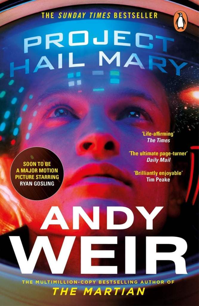 The book cover showing a guy in an astronaut helmet looking upwards, lights and stars reflecting from the glass.