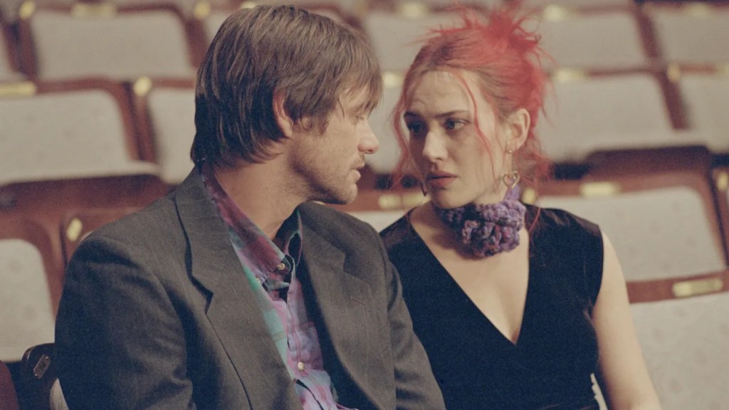 Joel (Jim Carrey) and Clementine (Kate Winslet) with orange hair sitting in an otherwise empty theater, looking at each other.