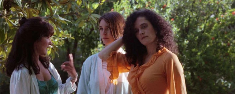 Three women talking in a garden.