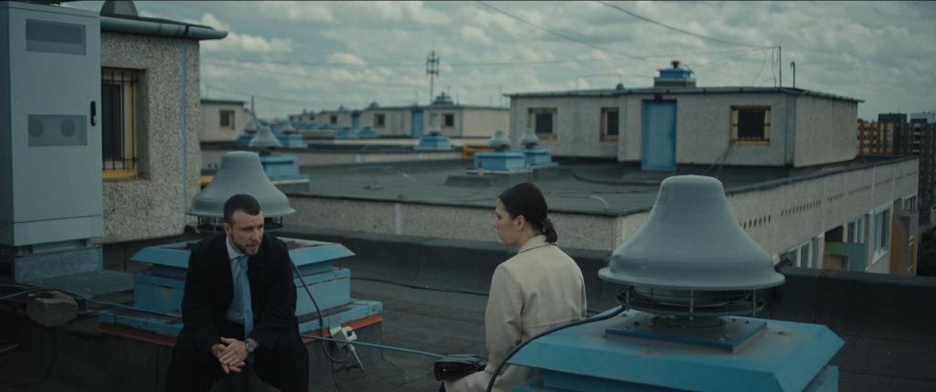 Marci (Áron Molnár) and Rita (Rozi Lovas) talking on the roof of a building.