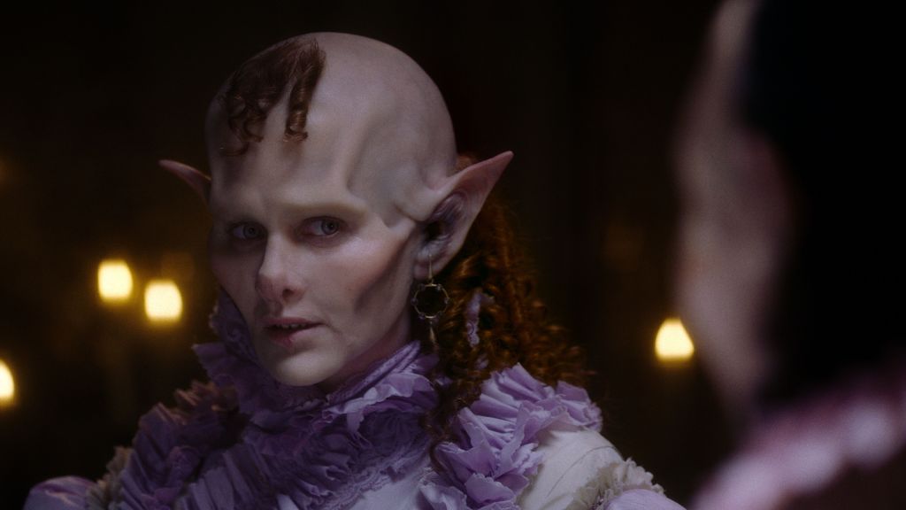 A vampire in a ruffled purple dress.