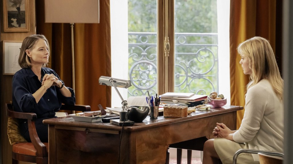 Lilian (Jodie Foster) at her desk, talking to a young woman.