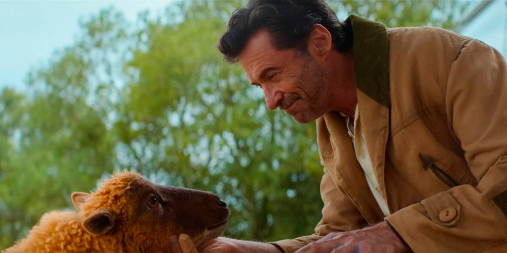Lily (Julia Louis-Dreyfus) and George (Hugh Jackman) looking at each other. He is smiling and holding her chin.