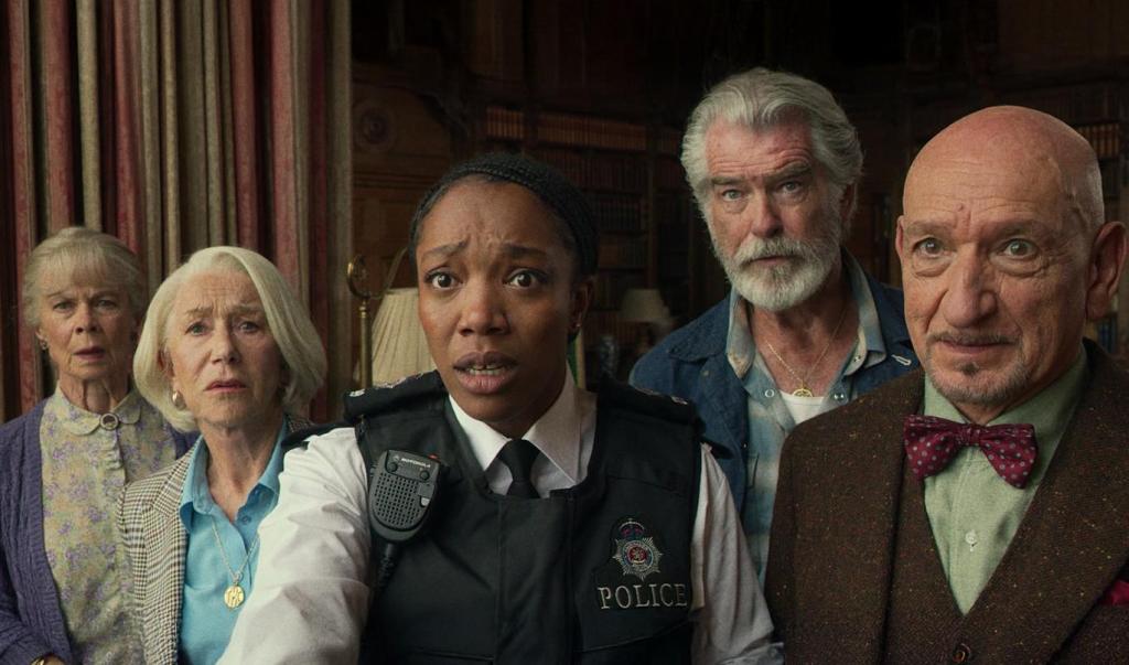 Joyce (Celia Imrie), Elizabeth (Helen Mirren), Ron (Pierce Brosnan) and Ibrahim (Ben Kingsley) together with police officer Donna (Naomi Ackie), all looking shocked.