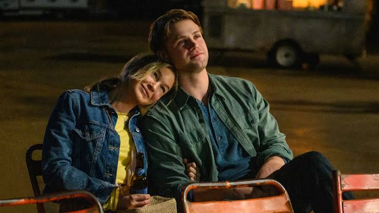 Bridget (Renée Zellweger) and Roxster (Leo Woodall) cuddling at an outdoor cinema.