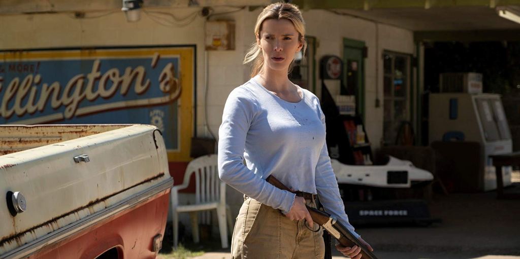 Crystal (Betty Gilpin) holding a shotgun in front of a gas station.