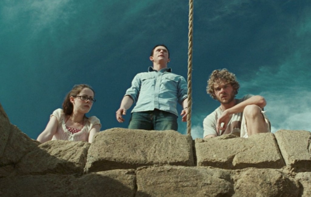 Amy (Jena Malone), Jeff (Jonathan Tucker) and Eric (Shawn Ashmore) looking down a well. 